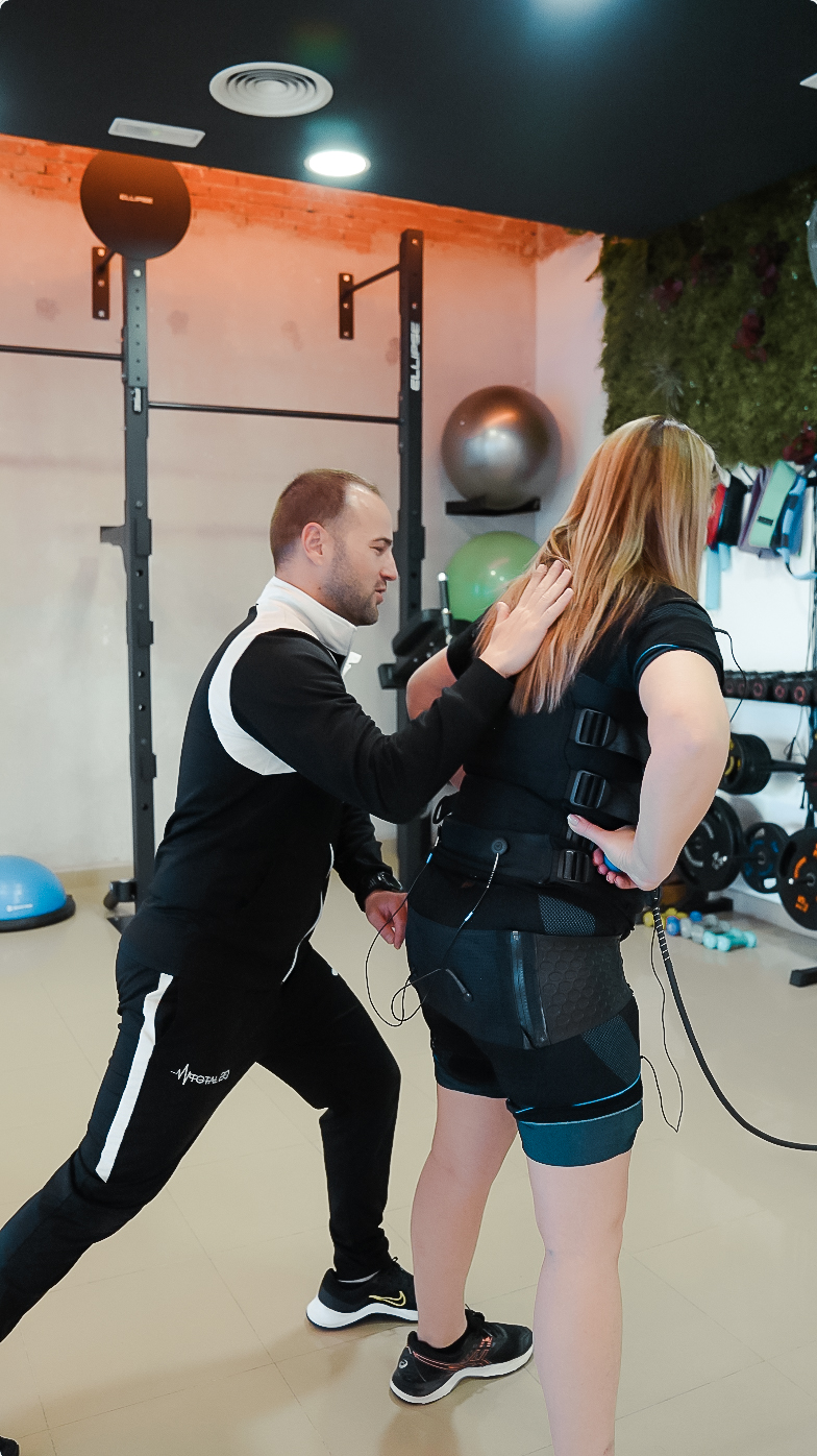 Cliente realizando sesión de electrofitness con supervisión profesional en Murcia